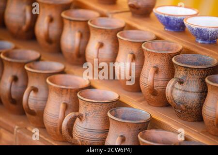 brown clay pots stand on a wooden shelf Stock Photo