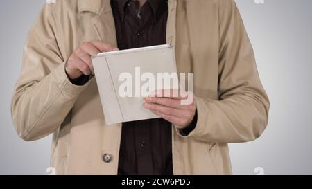 Hands of man using tablet on gradient background. Stock Photo