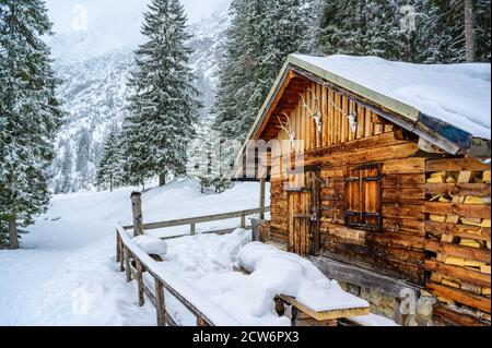 Wooden house in winter mountain landscape. Cottage / Hut in snowy mountains. Travel destination for recreation. Stock Photo