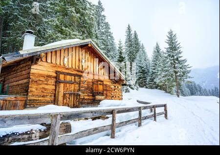 Wooden house in winter mountain landscape. Cottage / Hut in snowy mountains. Travel destination for recreation. Stock Photo
