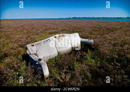 A ruin sofa lost in a field among weeds Stock Photo
