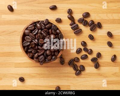 A bowl of coffee beans with a few beans falling naturally Stock Photo