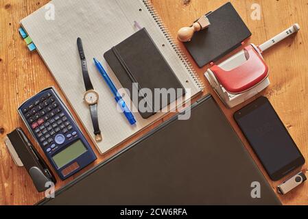 High angle shot of a work desk with office equipment. Office equipment on a wooden vintage table. Home office. Stock Photo