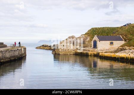 The small harbor at Ballintoy on the North Antrim Coast of Northern Ireland with its ancient stone built boathouse on a day in spring Stock Photo