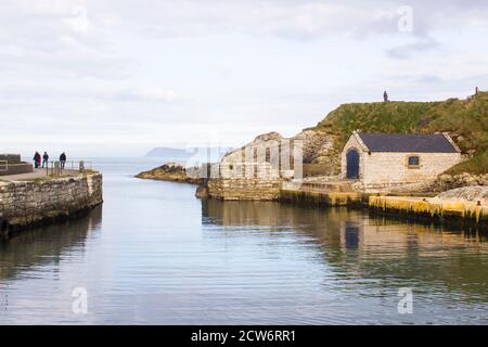 The small harbor at Ballintoy on the North Antrim Coast of Northern Ireland with its ancient stone built boathouse on a day in spring Stock Photo