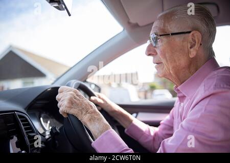 Worried Senior Male Driver Looking Through Car Windscreen Stock Photo