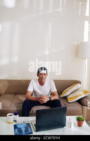 Man with fever vodeo calling doctor Stock Photo