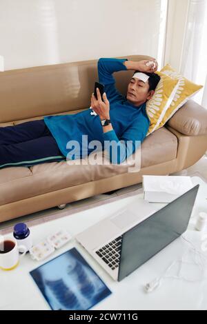 Sick man resting on sofa Stock Photo