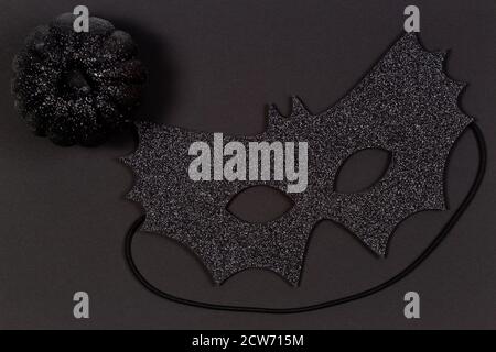 Black halloween maskand decorative pumpkins on black background. Top view Stock Photo