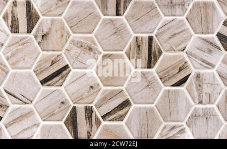Beige-and-brown ceramic tile in the form of honeycombs. Hexagonal floor tiles. Stock Photo