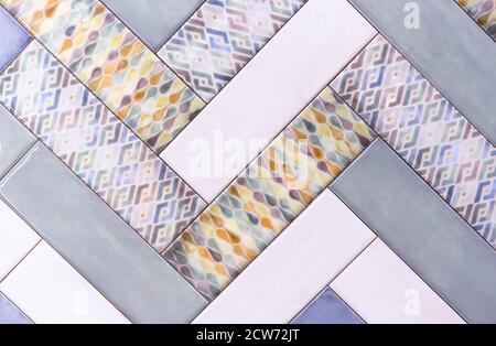 Multicolored ceramic tiles are arranged in a herringbone pattern. Stock Photo