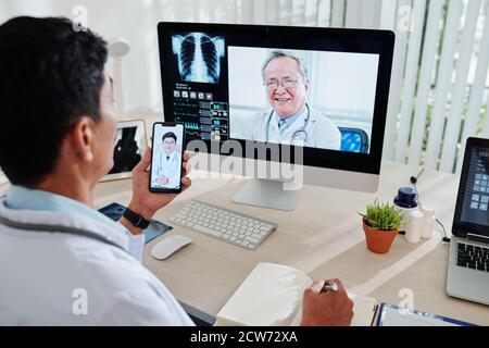 Doctor video calling colleagues Stock Photo
