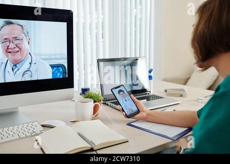 Cardiologist video calling her colleagues Stock Photo