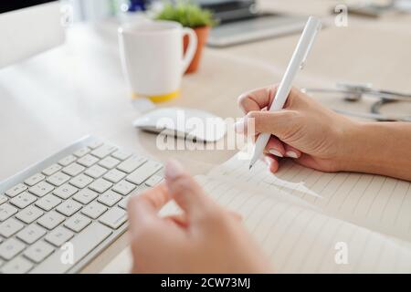Doctor writing in notepad Stock Photo