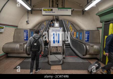 London, UK. 28 September 2020. Commuters travel into London during 'morning rush-hour', where the rush is still non-existent due to Covid-19 scare. Escalator sign with social distancing message at Earls Court underground station. Credit: Malcolm Park/Alamy Live News. Stock Photo