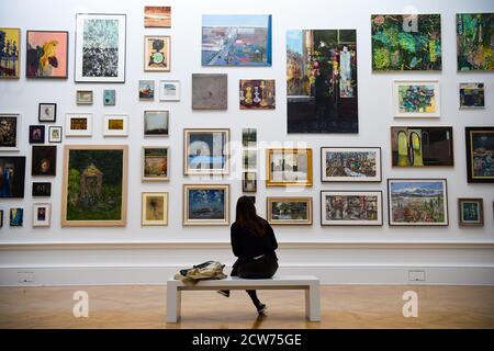 NOTE TO EDITORS. FOR USE IN RELATION TO THE EXHIBITION ONLY. A member of the public looks at various artworks at a preview for the 'summer' exhibition at the Royal Academy of Arts in London. The 252nd Summer Exhibition was postponed because of the coronavirus pandemic and will take place in the autumn for the first time. Stock Photo