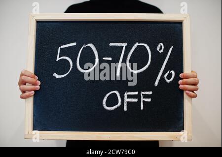 50-70 percents written on blackboard. Black friday concept. Boy hold board. Stock Photo