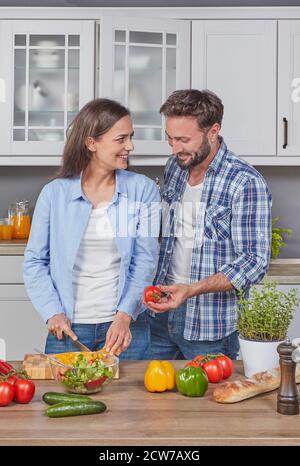 Young couple preparing a salad in the kitchen Stock Photo