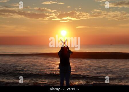 Silhouette of a woman raising hands at the beach. Dénia. Alicante ...