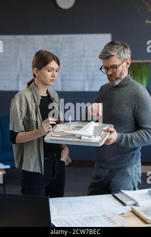 3d architects team working in office with building 3d model. Architects inspect building layout, planning construction project, searching new ideas Stock Photo