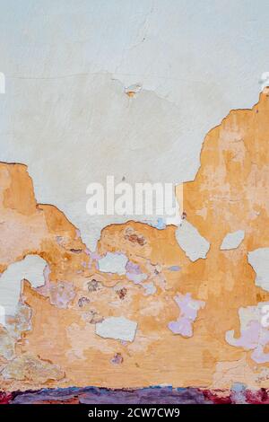 background of damaged weathered multicolored coating of paint of concrete building wall with many patches Stock Photo