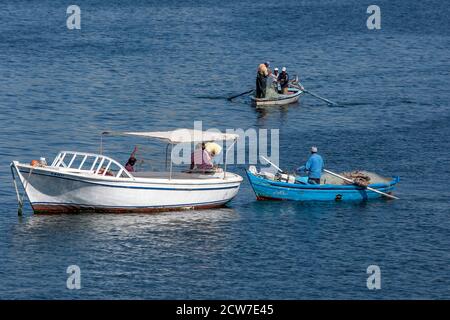 Fishermen in their boats checking nets on the Mediterranean Sea in Alexandria Harbour in northern Egypt. Stock Photo