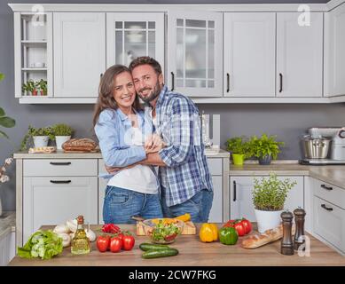 Happily married couple cooking together in the kitchen Stock Photo