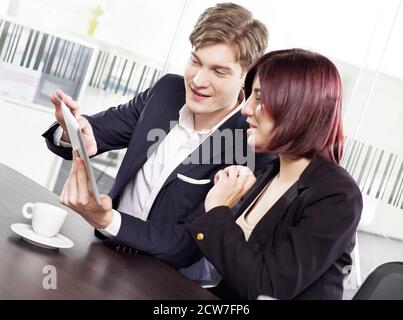 Co-workers looking at a digital tablet Stock Photo