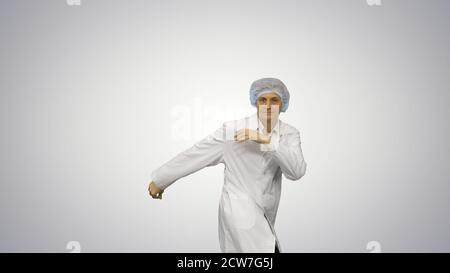 Young male doctor in white robe and protective cap dancing moder Stock Photo