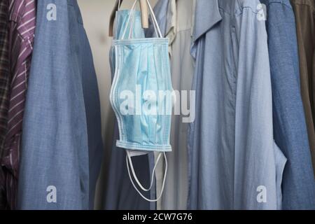 Different protective face masks hanging  with clothes Stock Photo