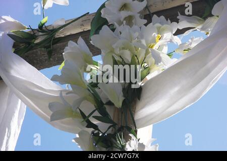 White drape and white lilies (symbols of the Resurrection) over a cross on Easter morning at a church in Virginia, USA Stock Photo