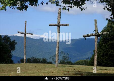 Three wooden crosses on a hill- Christian display reminding of Jesus' sacrifice on Golgotha Stock Photo