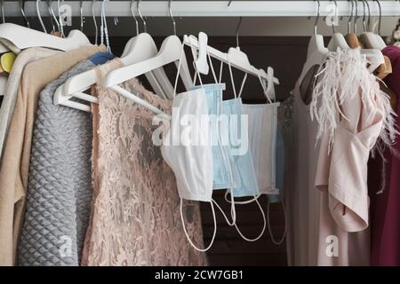 Different protective face masks hanging  with clothes Stock Photo