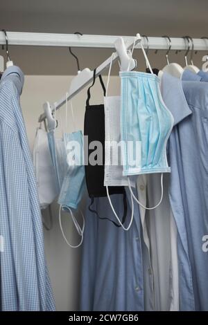 Different protective face masks hanging  with clothes Stock Photo