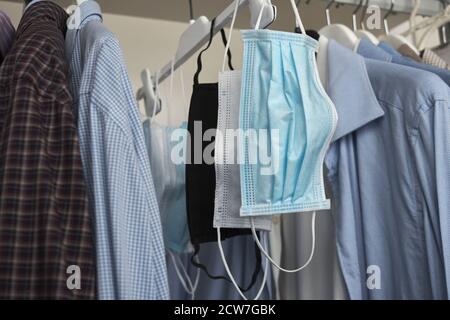 Different protective face masks hanging  with clothes Stock Photo