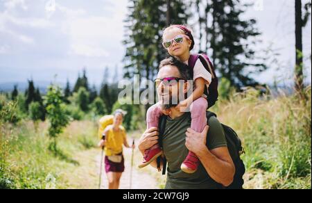 Family with small child hiking outdoors in summer nature. Stock Photo