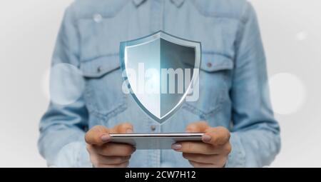 Woman holding phone with security shield hologram Stock Photo