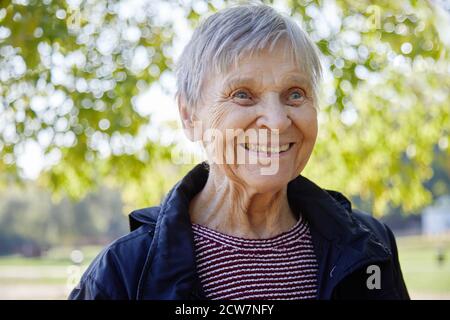 Portrait of ninety year old woman is smiling in the park. Stock Photo