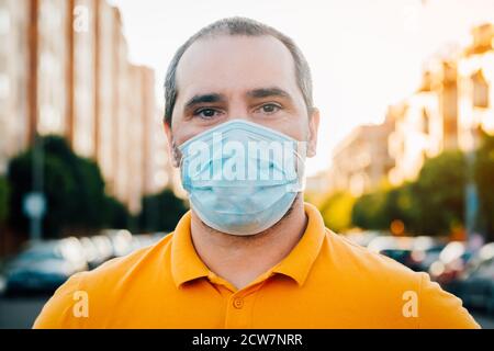 Close up portrait of 40s man in a disposable facial mask. Stock Photo