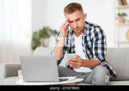Sad adult man using smart phone at home Stock Photo