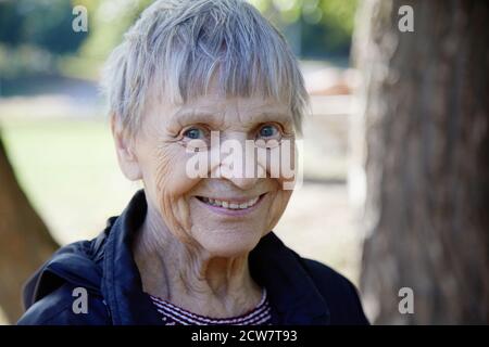 Portrait of ninety year old woman is smiling in the park. Stock Photo