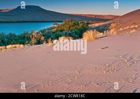 Big Dune over Sand Dunes Lake at sunrise, Bruneau Dunes State Park, High Desert region, Idaho, USA Stock Photo