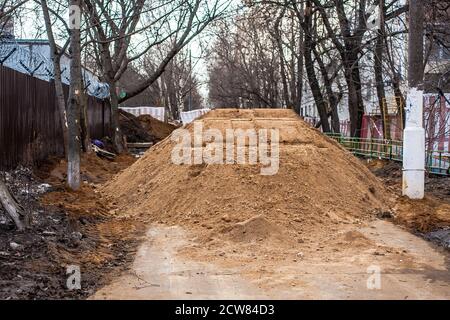 Big pile of sand on a footpath. Workers flooded the passage. Problems are not high-quality road repairs. Stock Photo