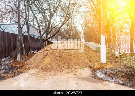 Big pile of sand on a footpath. Workers flooded the passage. Problems are not high-quality road repairs. Destroyed the pedestrian sidewalk Stock Photo
