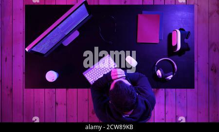 Tired programmer looking at some process on the computer. Stock Photo