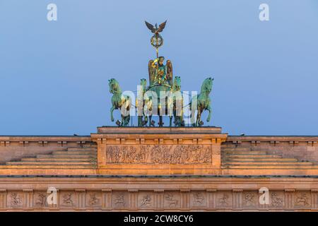 Sunrise at the the Brandenburg Gate (German: Brandenburger Tor), an 18th-century neoclassical monument in Berlin, Germany. Atop the gate is a Quadriga Stock Photo