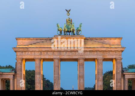 Sunrise at the the Brandenburg Gate (German: Brandenburger Tor), an 18th-century neoclassical monument in Berlin, Germany. Atop the gate is a Quadriga Stock Photo