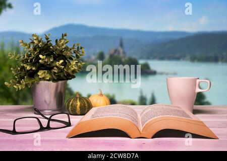 an open book on a wooden table in front of the lake panorama Stock Photo