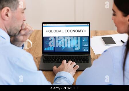 Businessman And Businesswoman Working On Laptop With Statistics Data Indoor Stock Photo