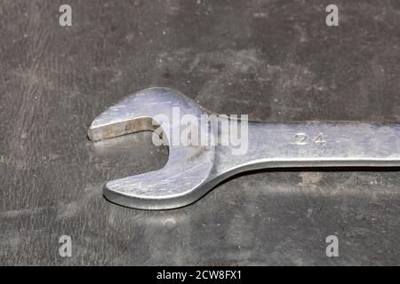 Close-up of old chrome wrench on a dirty table in repair shop Stock Photo
